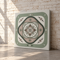 A square canvas wall art print with a geometric mandala design in muted sage green, beige, and dark charcoal, leaning against a white brick wall on a concrete floor.