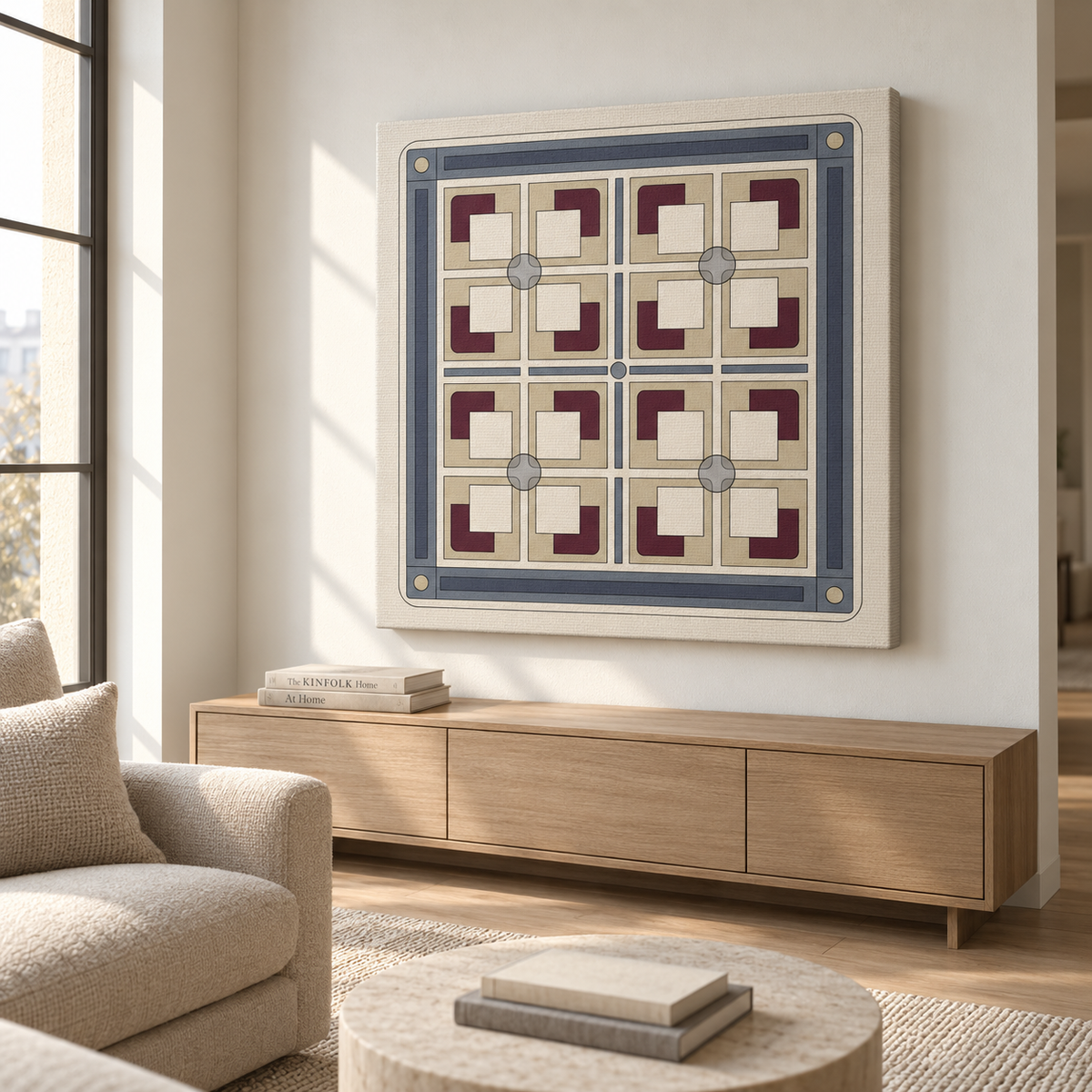 A framed square wall art print with a geometric pattern in cream, blue, and burgundy, displayed on a light beige wall above a wooden console in a modern living room setting.