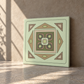 A square decorative tile or art print with a retro geometric pattern in sage green, beige, and brown, leaning against a textured beige wall on a stone floor with soft sunlight and shadows.